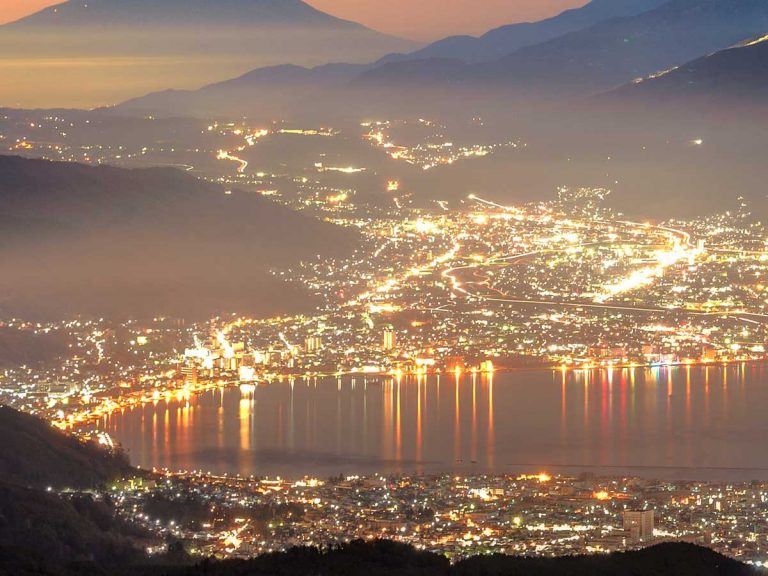 Japanese photog captures Mt. Fuji and Lake Suwa, lights glimmering like jewels before dawn