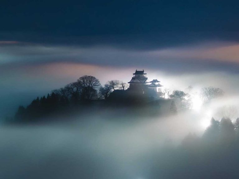 Japanese photographer captures ethereal image of “the castle in the clouds” at night