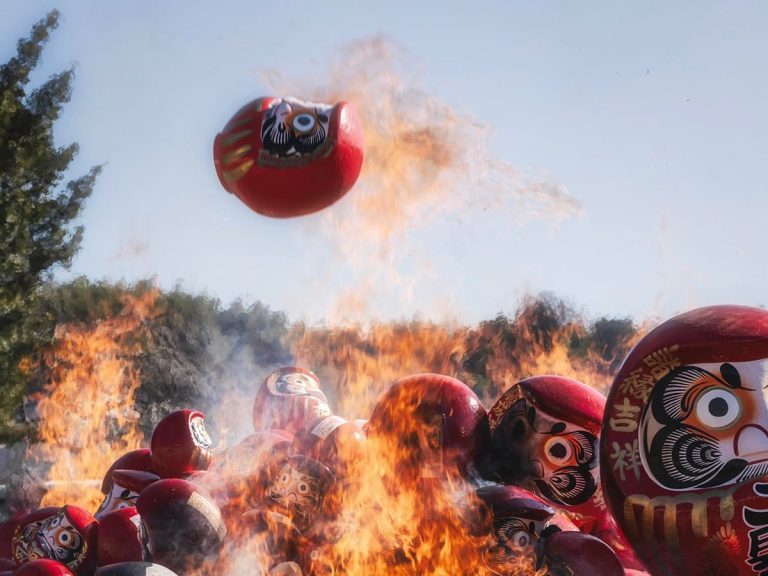 Japanese photographer captures a flying Daruma doll “escaping” the flames of a ritual bonfire