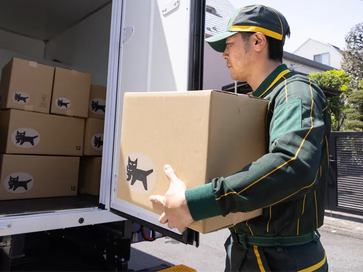 荷物を運ぶ配達員の写真