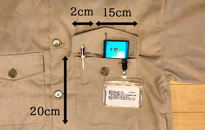 超撥水２WAYシェフジャケットの左胸のポケットに、ペンとスマートフォンを入れて、ケースに入れた社員証を吊り下げている
