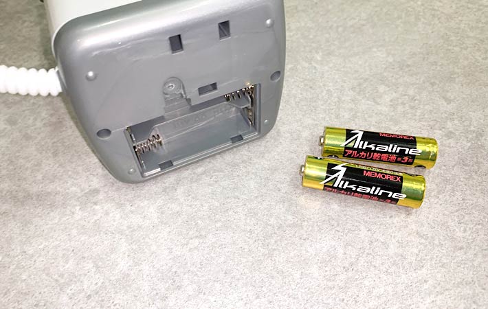 『ミニ洗濯機（電池式）』の底部分にある電池を入れる部分のフタを開け、単三電池２本を出した様子