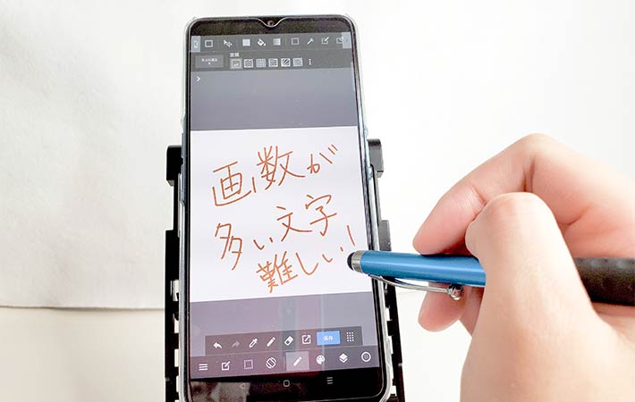 『タッチペン付きボールペン ０.５mm 黒』のタッチペン部分を使用して、スマートフォンの画面に文字を書いてみた様子