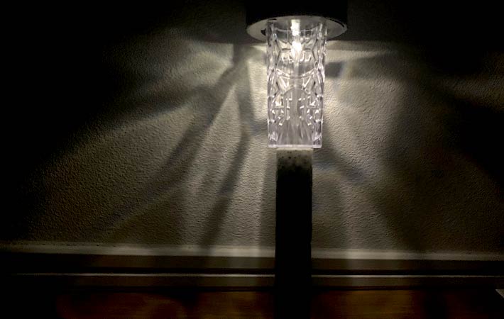 照明を暗くした室内で『ソーラーガーデンライト（石目調）』を灯し、狭い範囲だけが照らされている様子