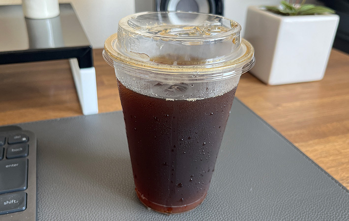 結露するアイスコーヒーが入ったプラスチックカップ