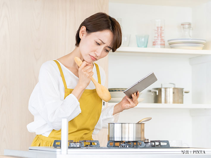 料理中に悩む女性の写真