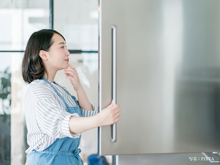 冷蔵庫を開ける女性の写真