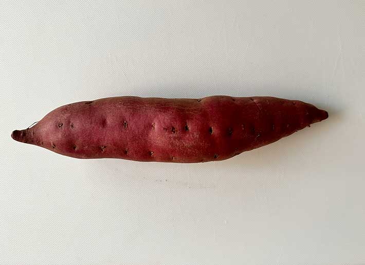 まな板に乗ったサツマイモの写真