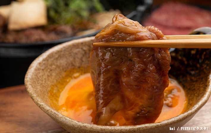 すき焼きのお肉を箸で持ち上げる写真
