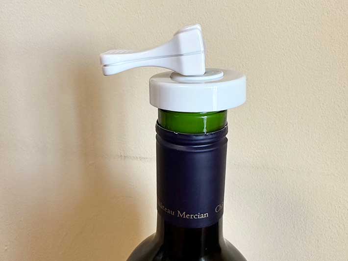 ダイソーの『何度でも使えるボトルキャップ』をワインボトルの口に装着しレバーを倒した様子の写真