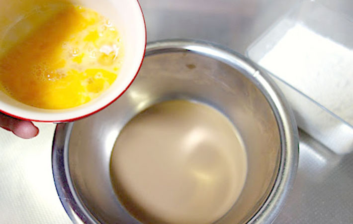 お湯で混ぜた『ブレンディスティック紅茶オレ』に溶き卵を入れている様子