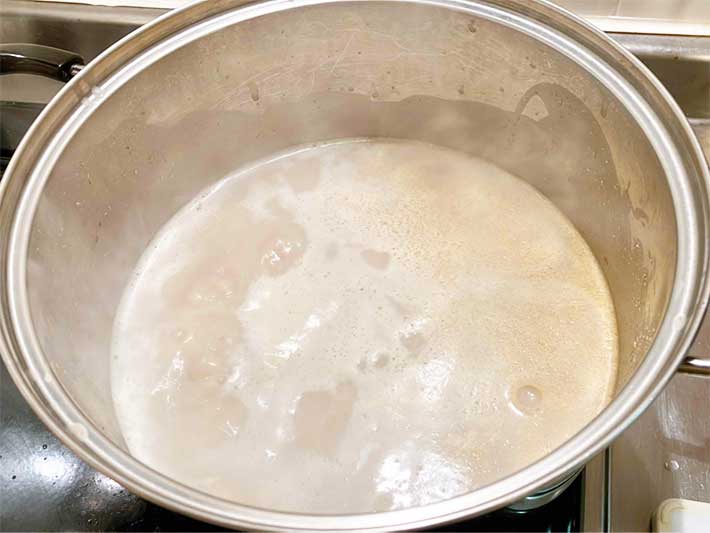 『〆まで美味しいごま豆乳鍋つゆストレート』を鍋に入れ煮立たせている写真