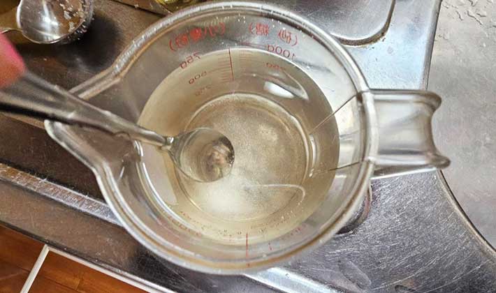 穀物酢１/４カップと塩大さじ１/３そして水３/４カップを混ぜて酢水をつくる様子