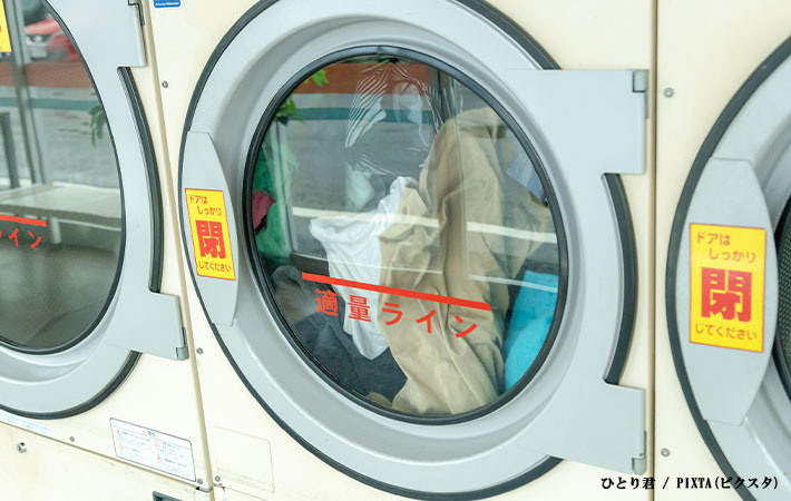 ドラム式洗濯機の中で回る洗濯物の写真