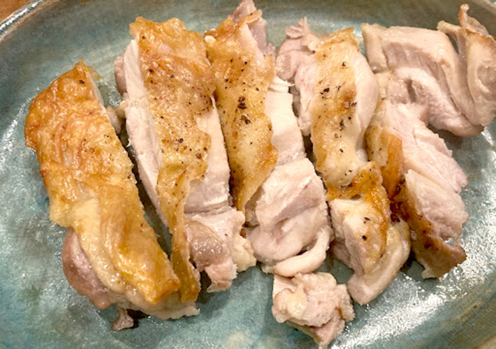 焼きあがった鶏モモ肉を一口大に切り皿に盛り付けた写真