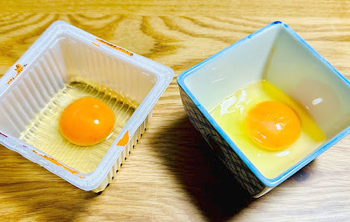 凸凹が付いた豆腐の容器とツルツルの陶器の小鉢に入れた卵の写真