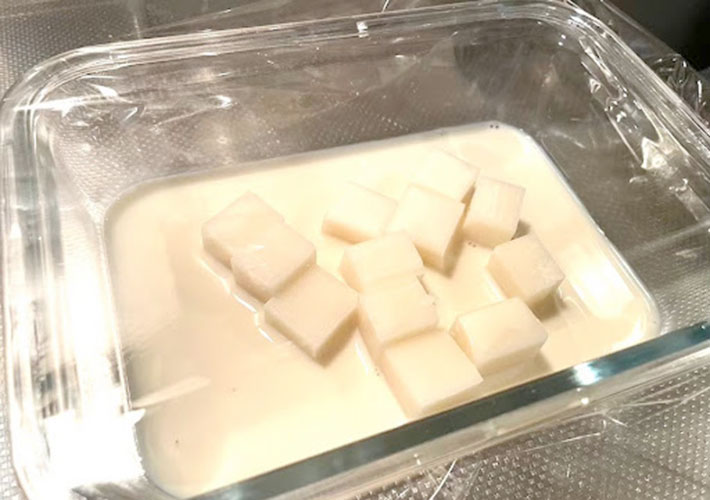 耐熱皿に小さく切った切り餅をト乳に浸しラップをかけた様子の写真