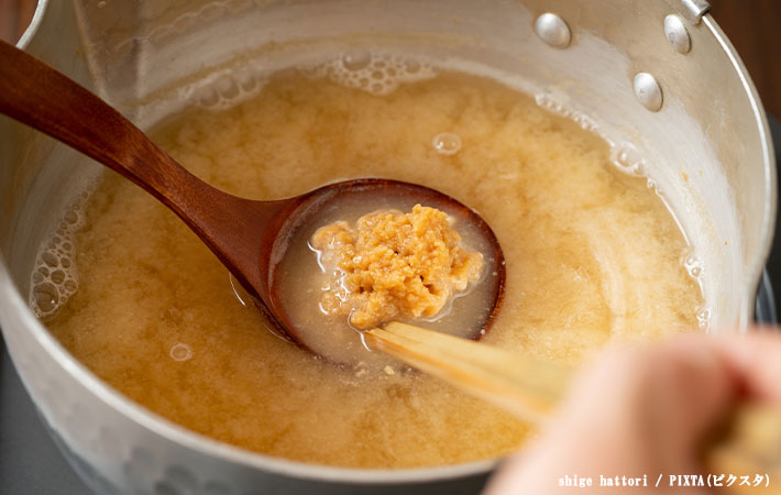 お鍋のスープに味噌を溶いている写真