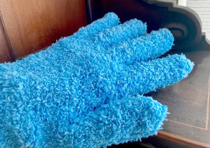 『マイクロファイバーおそうじ手袋』で家具のホコリを掃除している様子の写真