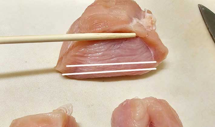 カットした鶏むね肉の断面図から見て繊維の筋の向きが分かる白線を記した写真