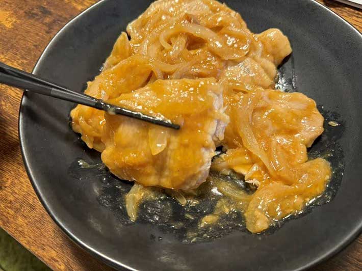 箸で肉が切れるほど肉が柔らかくなっている生姜焼きの写真