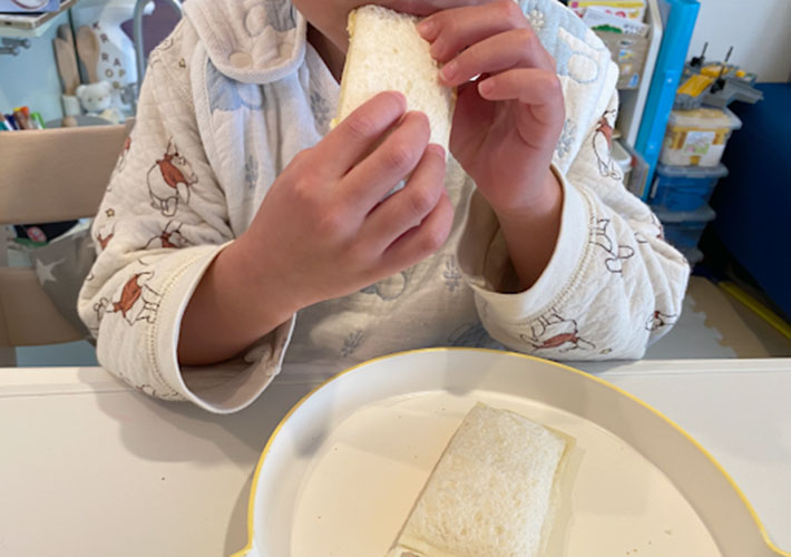 サンドイッチを食べる子供の写真