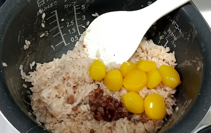 炊けた『カンタンしるこdeお赤飯』に小豆と栗の甘露煮を混ぜ入れている写真