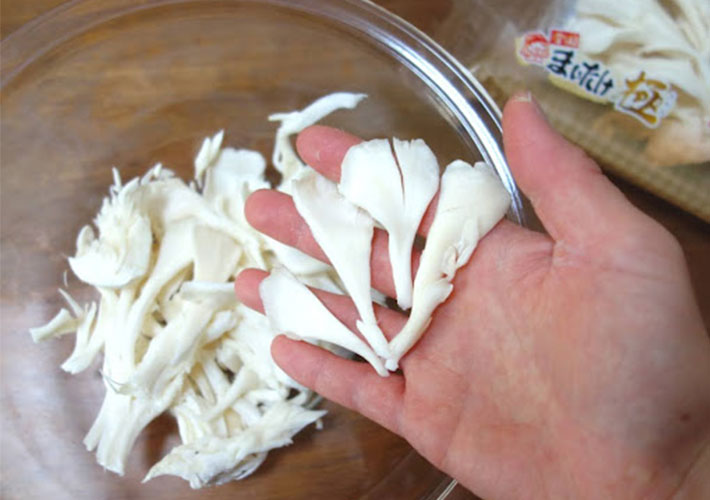 白マイタケを手で食べやすい大きさにさいて耐熱ボウルに入れている写真