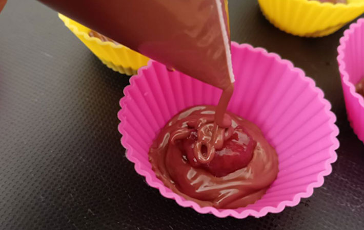 溶かしたチョコレートをシリコンカップに入れている写真