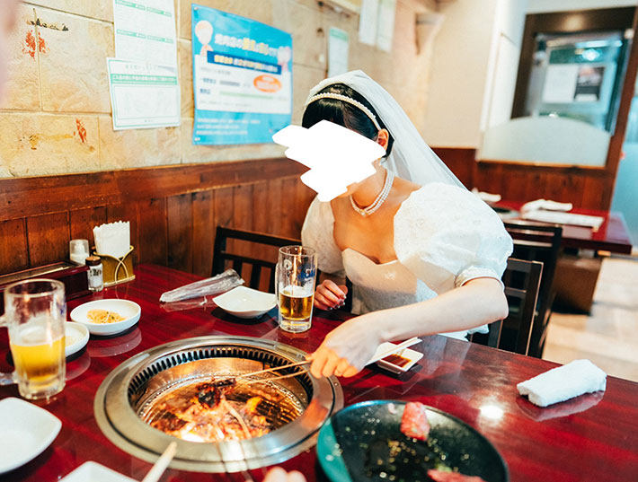 ウエディングドレス姿で焼肉を食べる写真