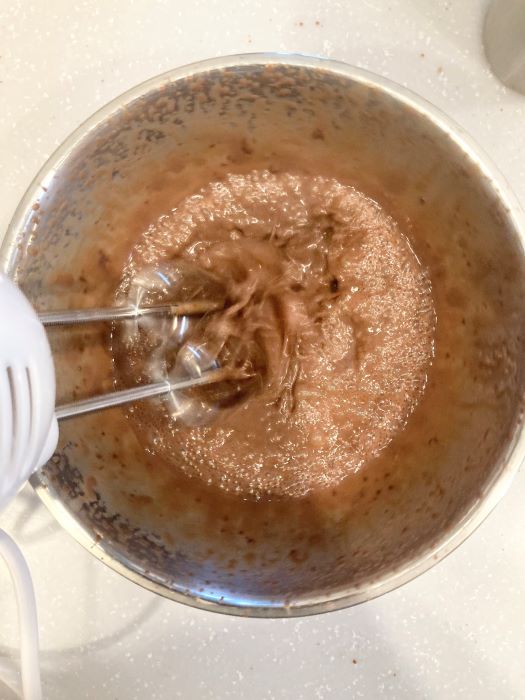 チョコレートと牛乳を混ぜた液体に泡立て器をかけている様子