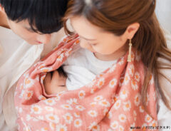 赤ちゃんに授乳をする母親とお父さんの写真