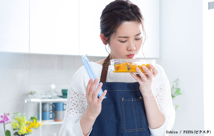 食材の匂いを確かめる女性の写真