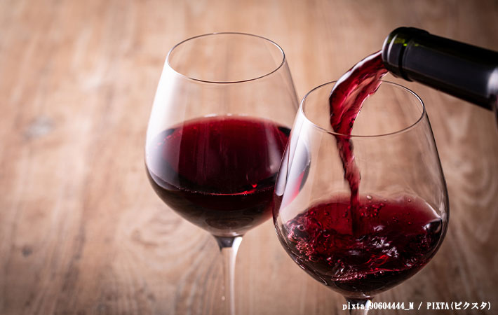 ワイングラスに赤ワインを注ぐ写真