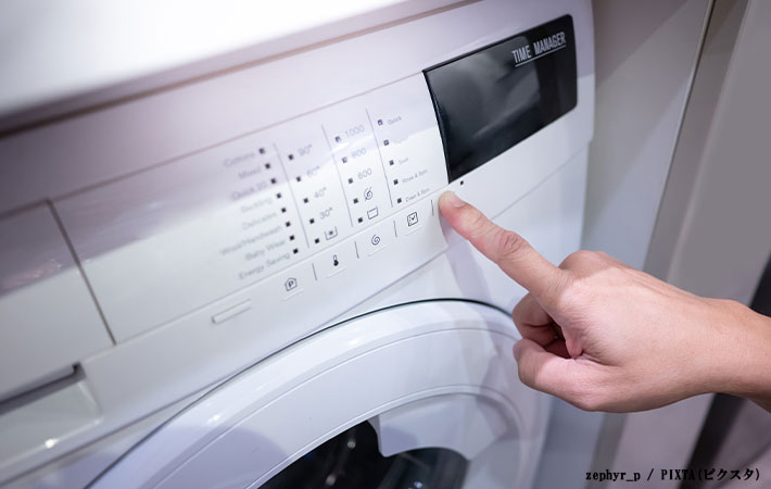 洗濯機のボタンを押す写真