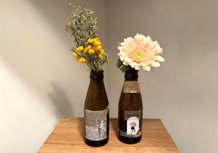シールでリメイクしたオロナミンCの瓶に花を挿して花瓶にした写真
