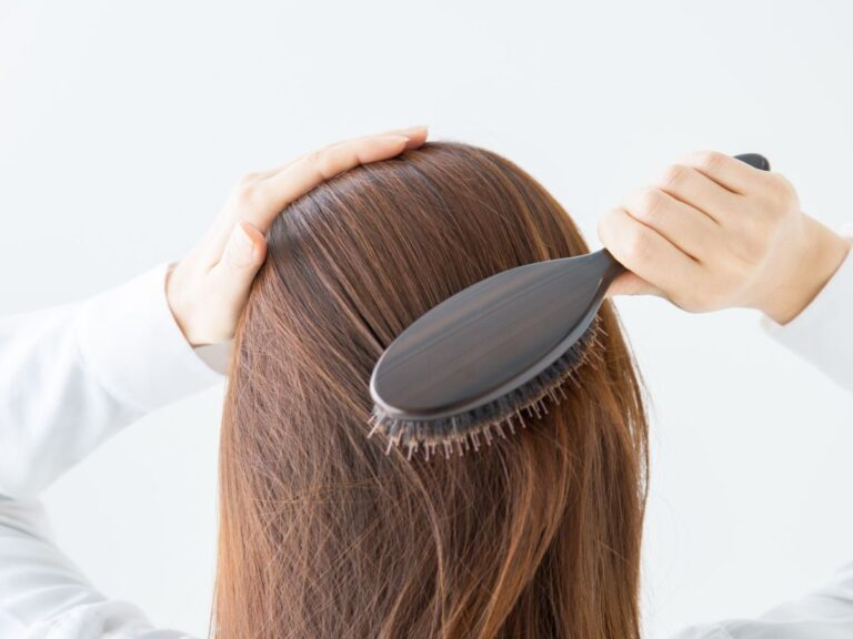 ブラシで髪をとかしている女性