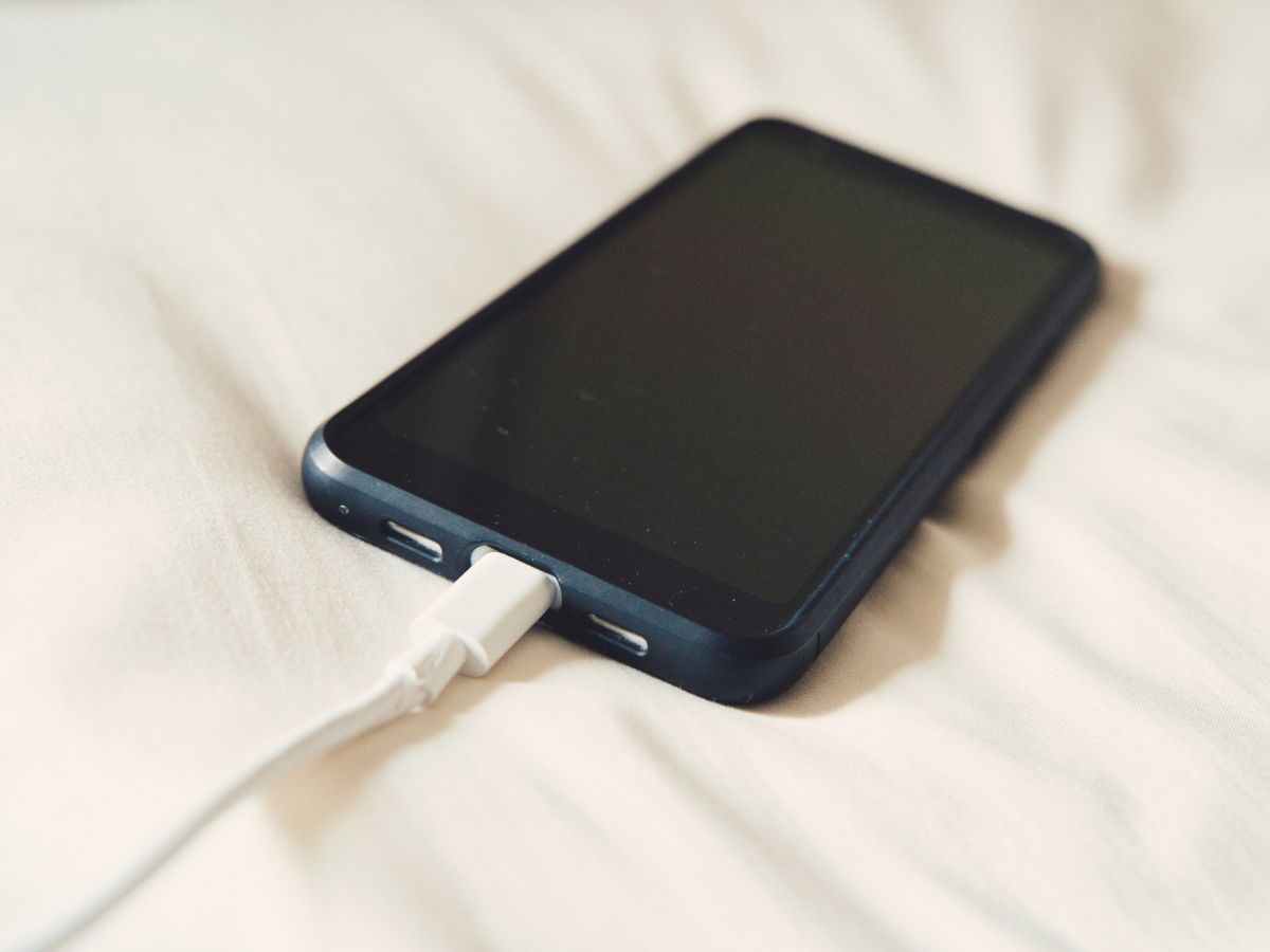 ベッドの上に置かれたスマートフォン