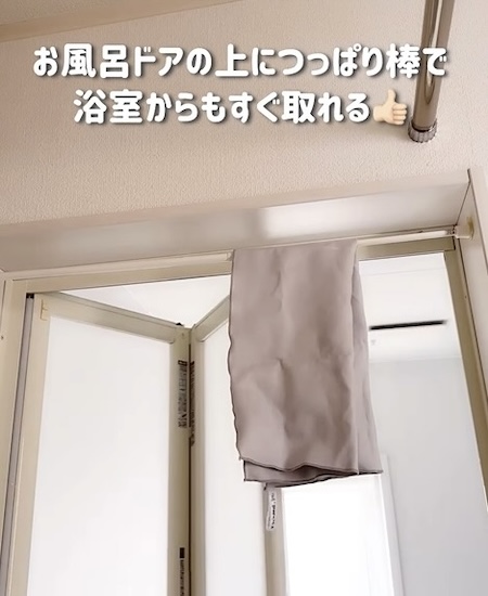 浴室のドア枠につっぱり棒をかけてタオルを干している様子