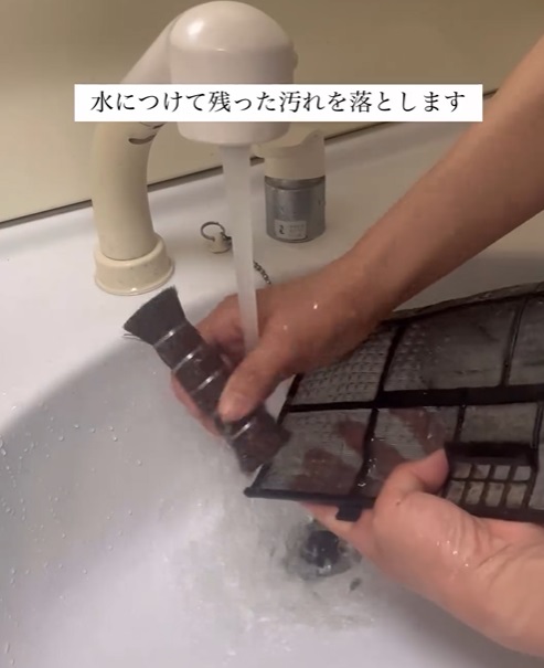 エアコンのフィルターを水洗いしている様子