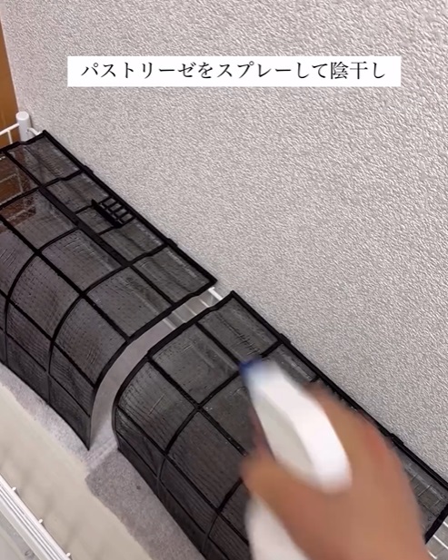 エアコンのフィルターにスプレーを吹きかけている様子