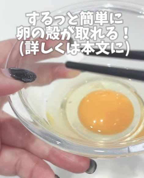 菜箸で卵の殻を取ろうとする様子
