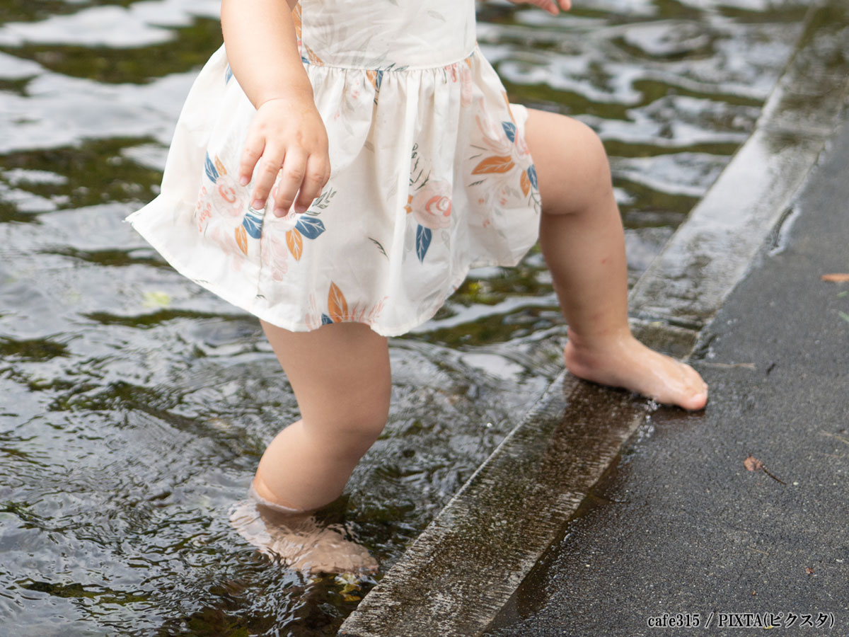 公園のじゃぶじゃぶ池で遊ぶ女の子の写真