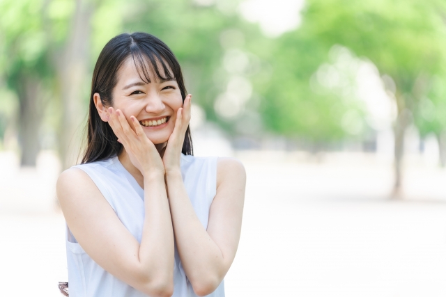 新緑の中で笑顔の日本人女性の画像