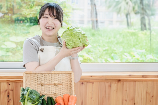 野菜と笑顔の若い女性の画像