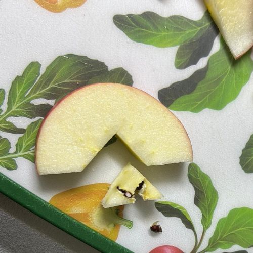 輪切りにしたリンゴをさらに半分に切り、芯を三角に切って取り除いた様子