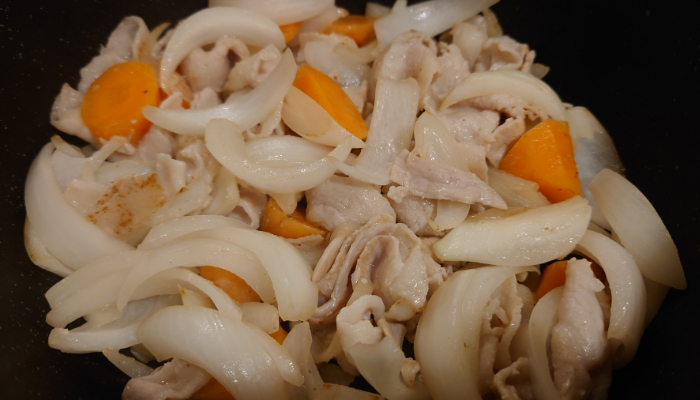 鍋にサラダ油を熱し、牛細切れ肉（今回は豚肉を使用）、玉ねぎ、にんじんを順に加えて炒めます。