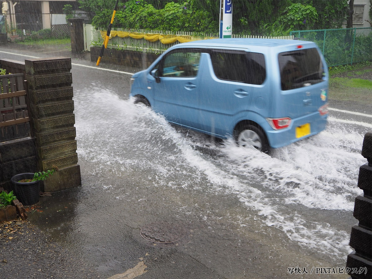 冠水した道路を走る車の写真