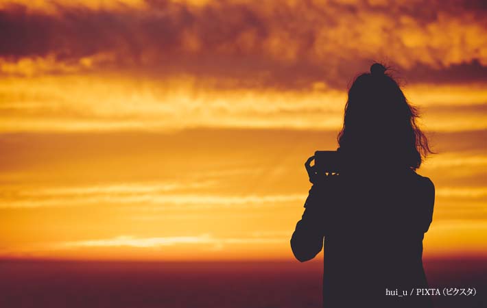 夕焼け空と女性のシルエットの写真