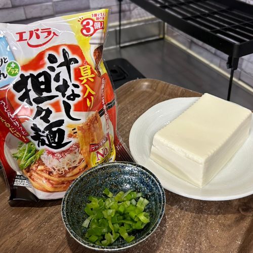 豆腐とカットしたネギ、エバラプチッとうどんプラス 具入り汁なし担々麺を並べた写真